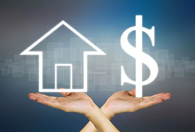 hand holding illustration of house and dollar sign